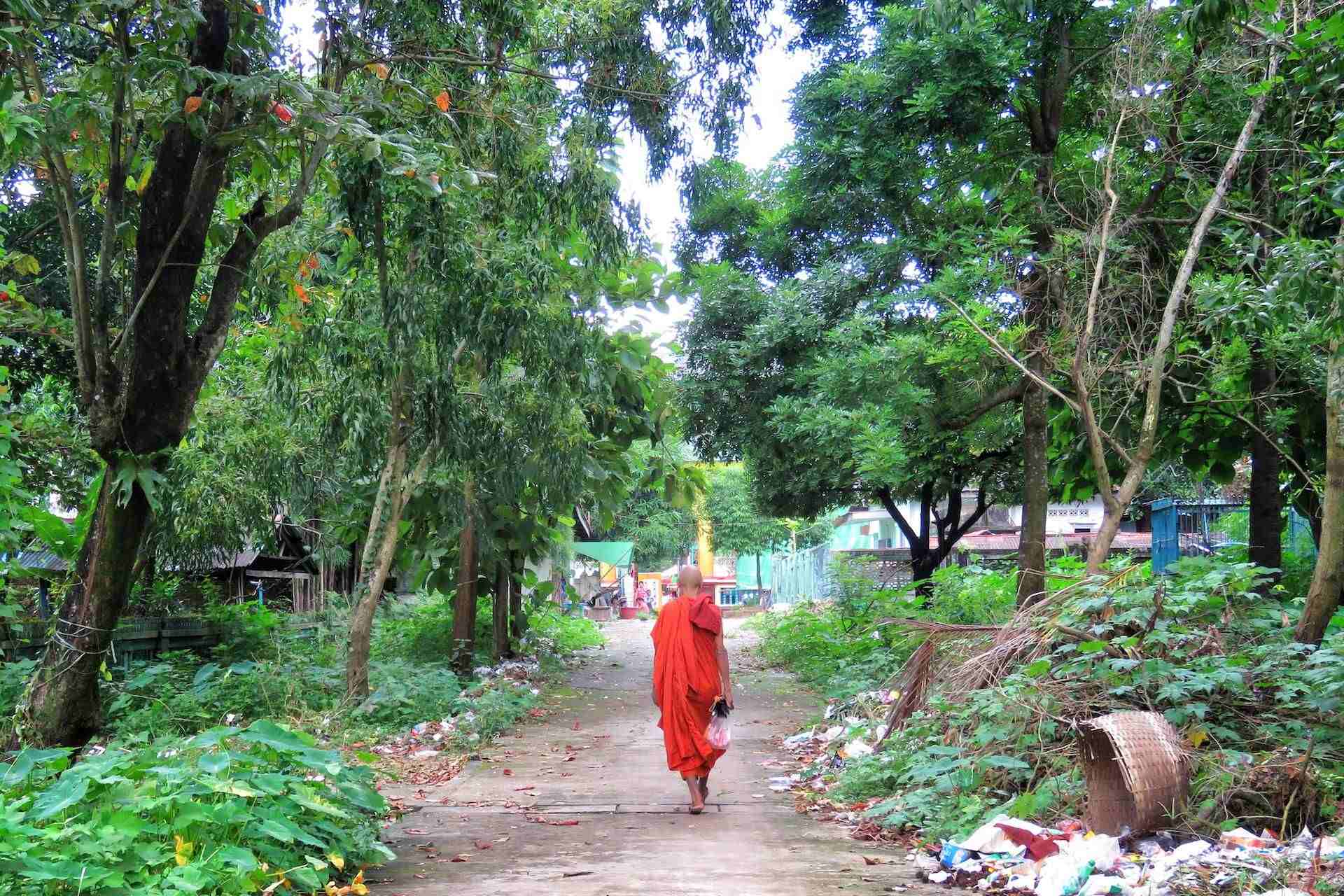 man in monk suit walking on road during daytime