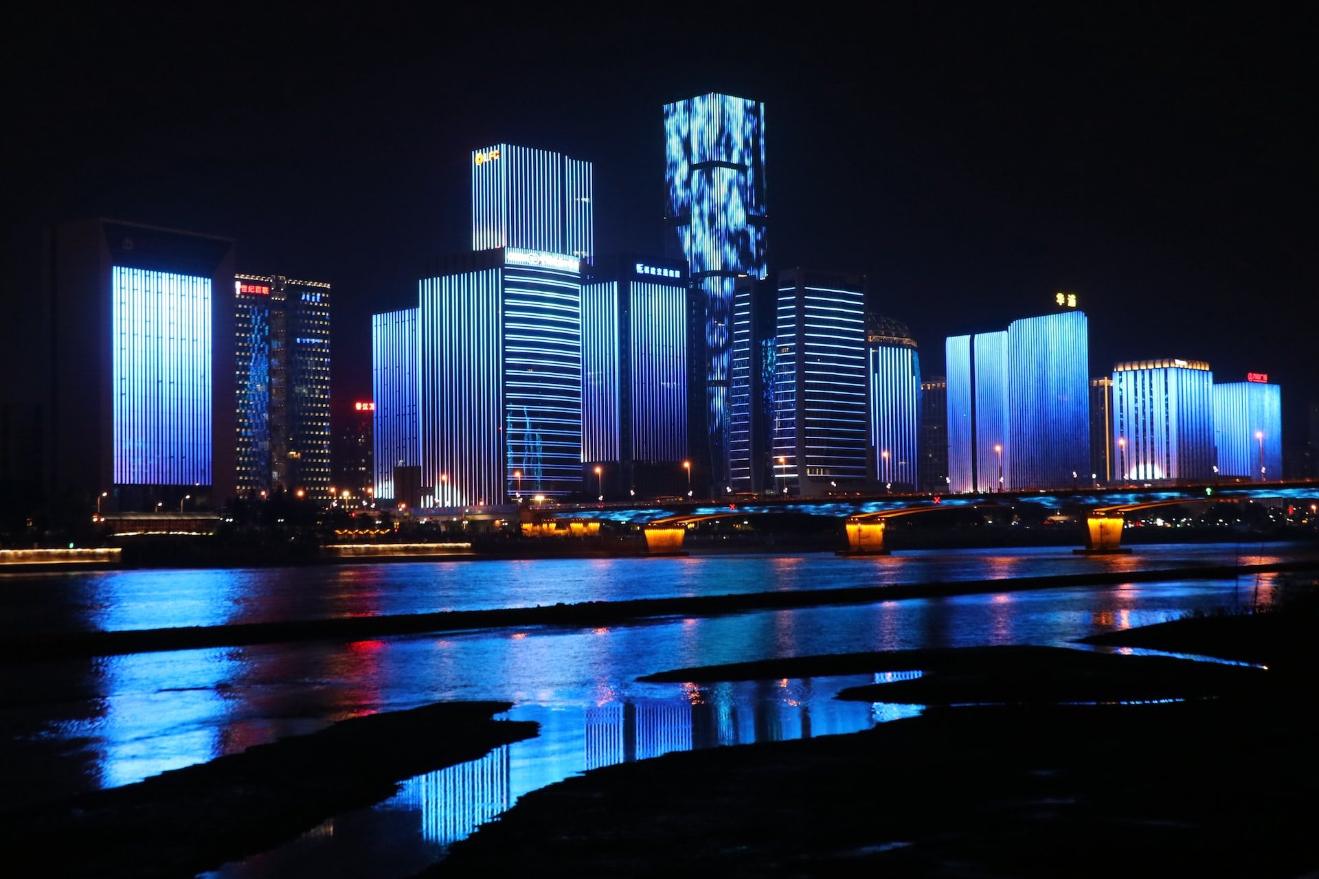 photography of lighted buildings reflecting on water