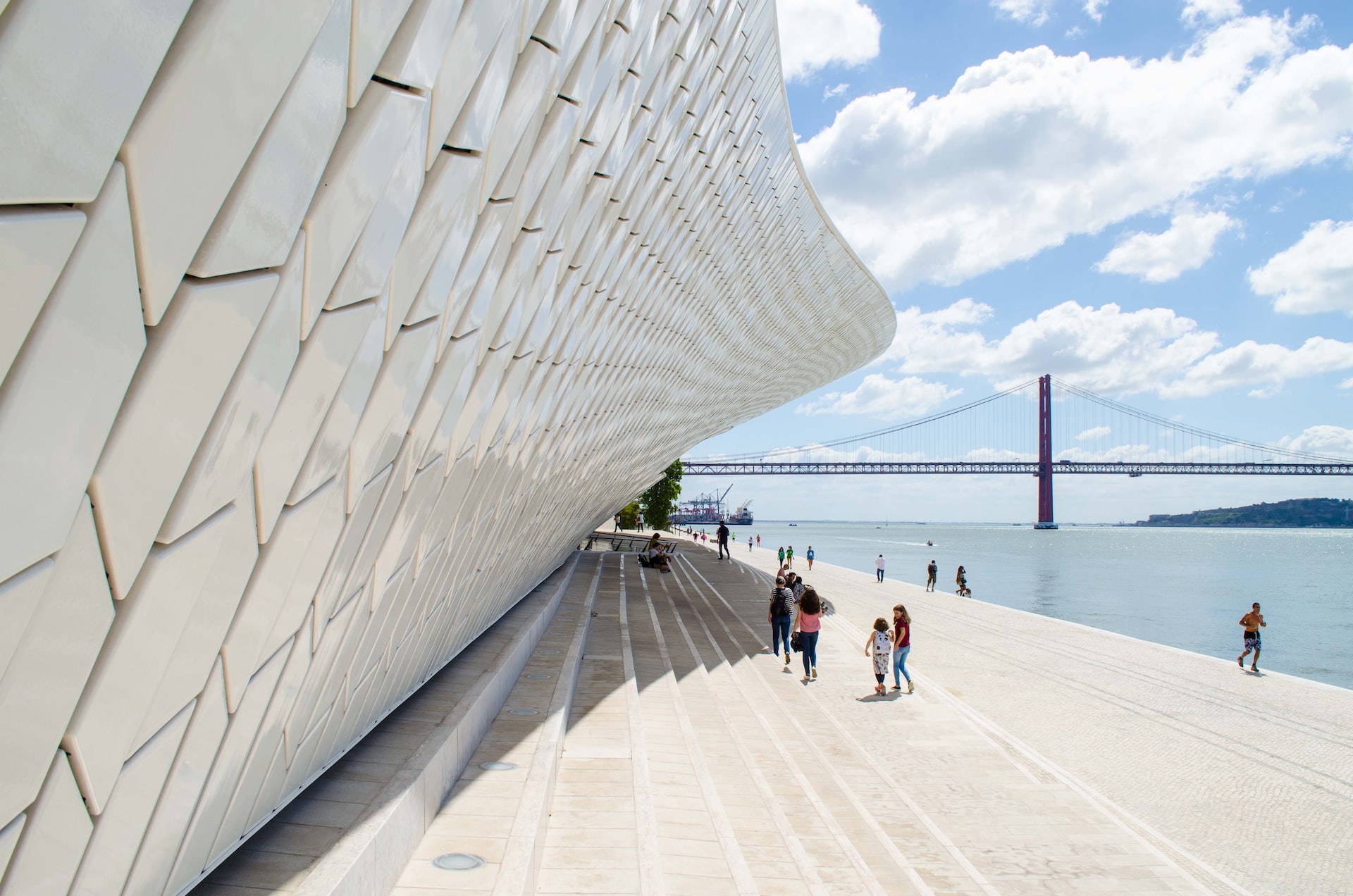 people walking on white concrete bridge under blue sky during daytime