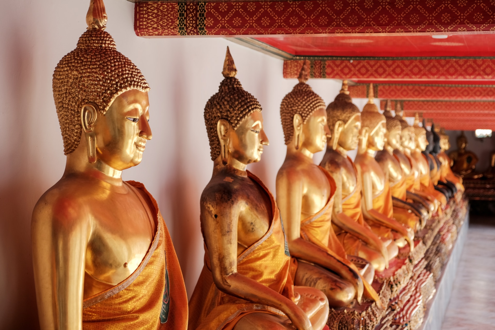 gold buddha statue on red and white textile