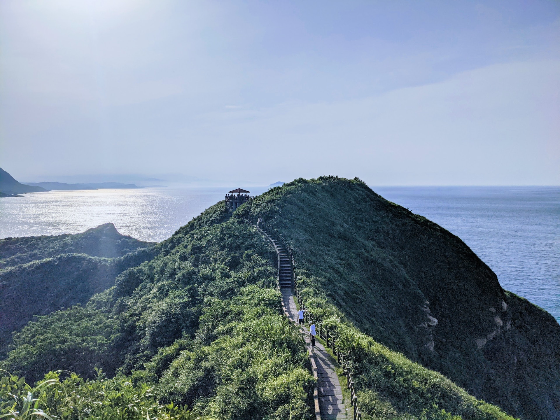 green mountain beside body of water during daytime