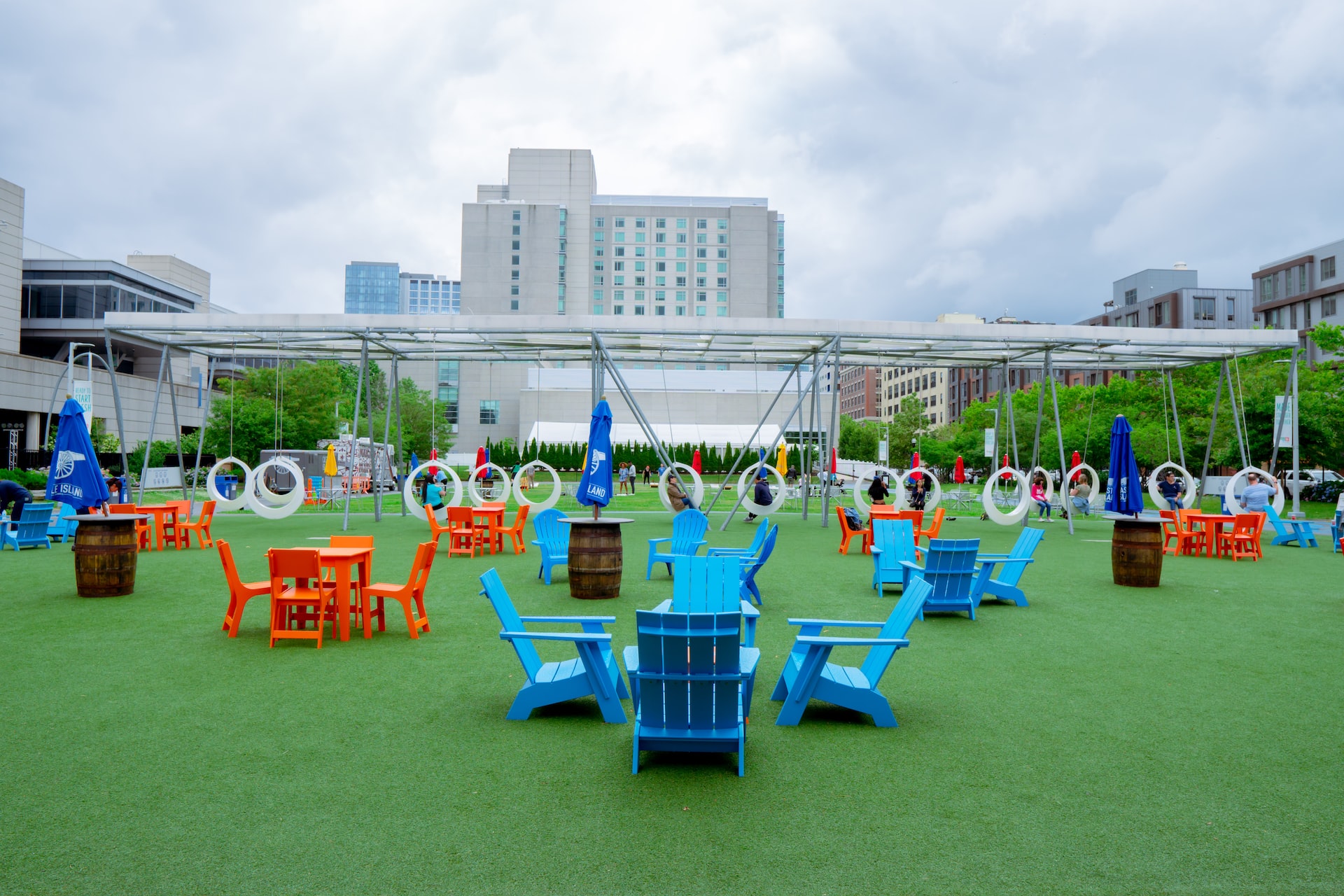 a group of blue and orange chairs sitting on top of a green field