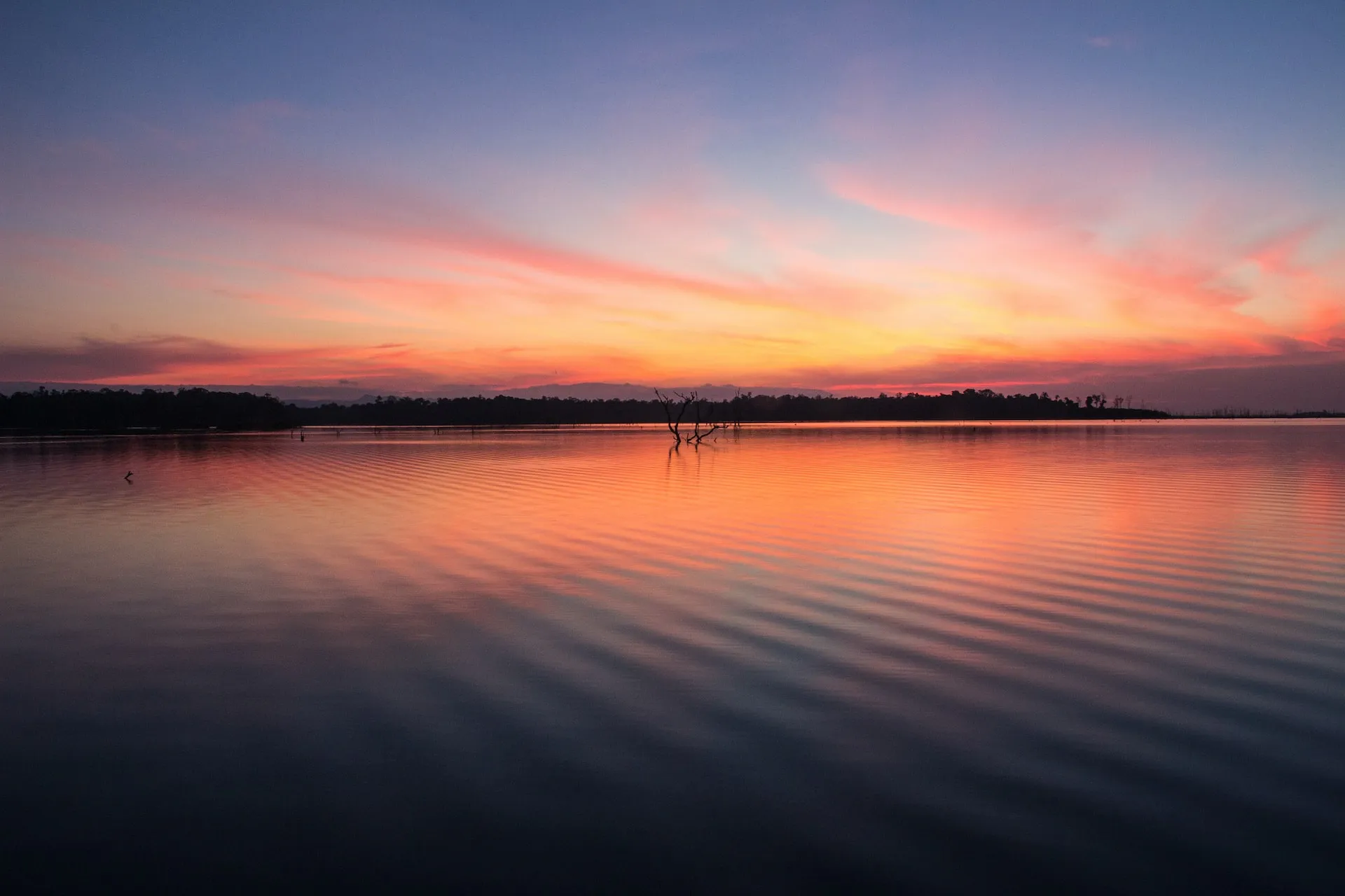 reflection of orange sky on still water