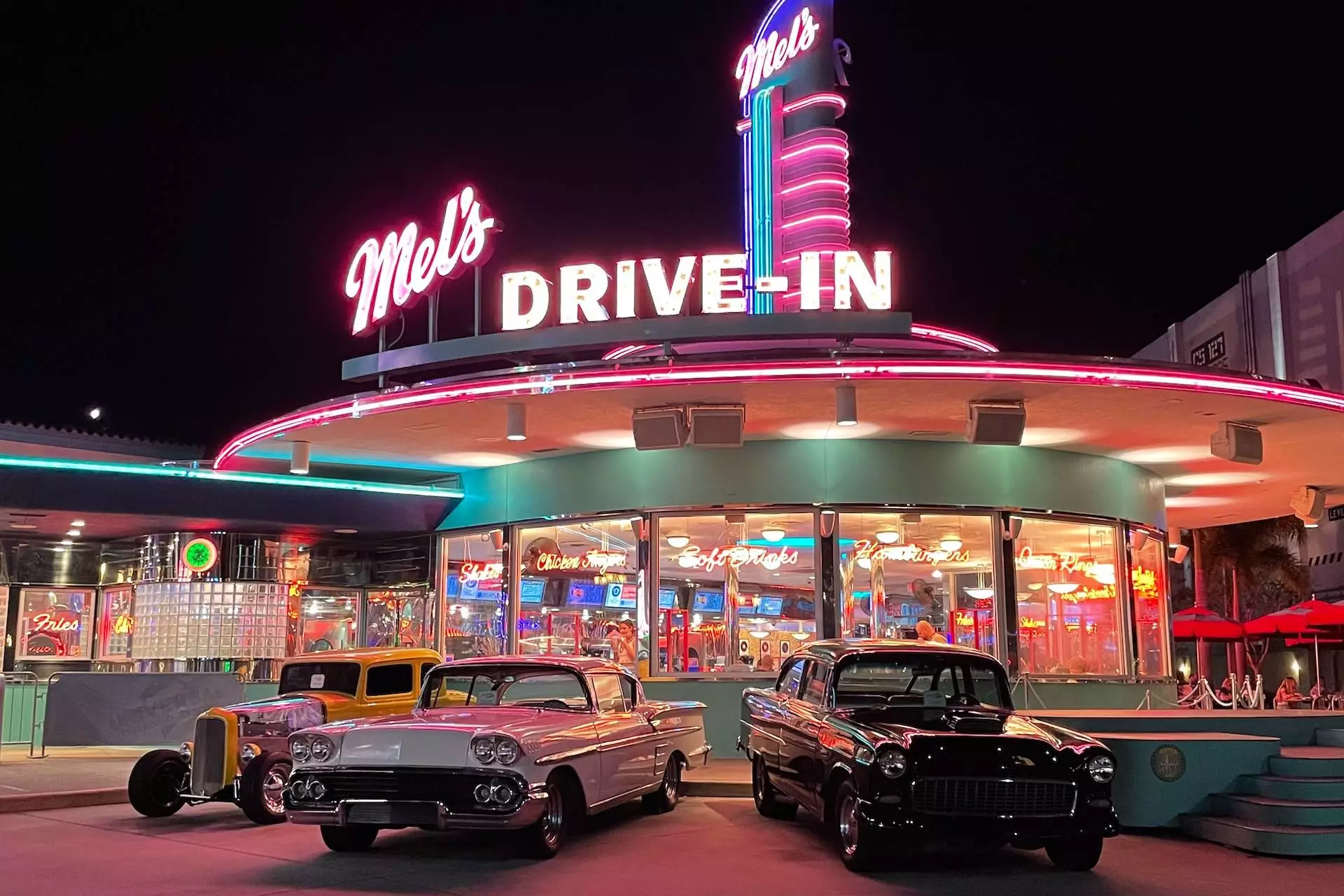 black sedan parked in front of UNKs restaurant during night time